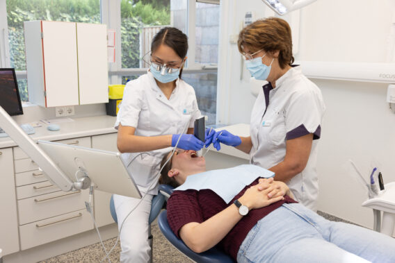 Dentist and assistant treat patient - Dental Clinics Oudenbosch