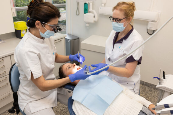 Patient opens mouth in chair - Dental Clinics Oudenbosch