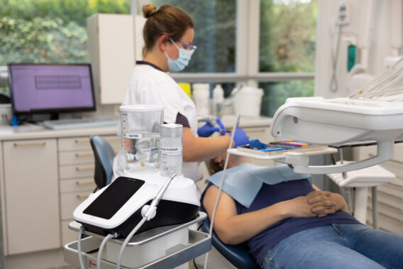Clinician treats patient in chair - Dental Clinics Oudenbosch
