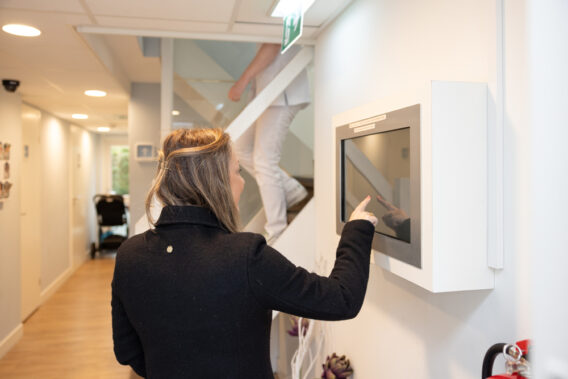 Photo of a patient checking in at the check-in kiosk at Dental Clinics Reeshof