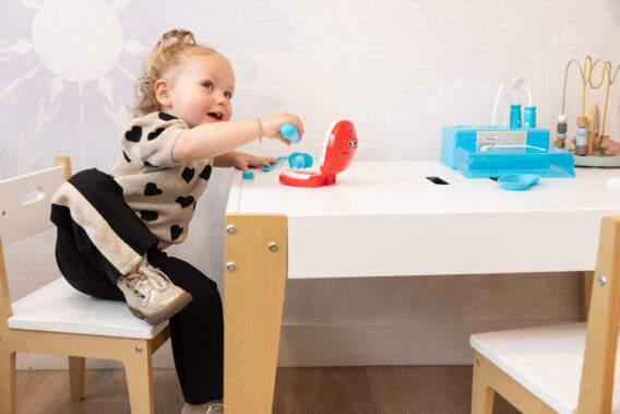 A toddler playing at the toy table at Dental Clinics Reeshof