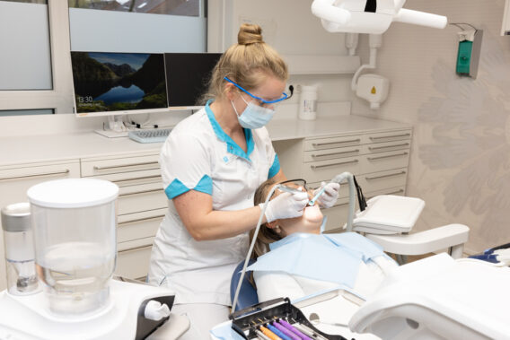 Photo of a patient in the dental chair being treated by the dentist at Dental Clinics Reeshof