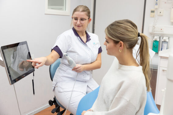 Behandelaar wijst naar gebit op scherm - Dental Clinics Ermelo