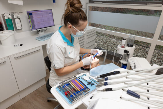 Behandelaar behandelt patiënt met open mond - Dental Clinics Ermelo
