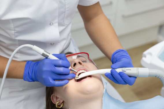 Gezicht van patiënt in stoel met open mond en instrumenten Dental Clinics Hoorn