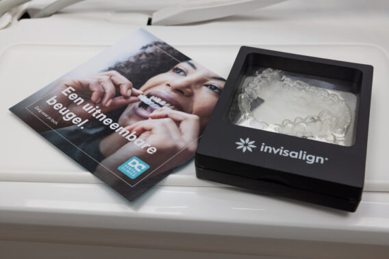 Brochure 'Een uitneembare beugel' naast een doosje van invisalign Dental Clinics Almere Perspectief