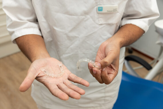 Handen van tandarts waarop een aligner ligt Dental Clinics Almere Perspectief