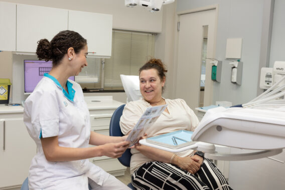 Tandarts legt de patiënt iets uit bij Dental Clinics Gouda Burghvliet