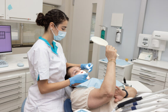 Patiënt ligt in de stoel en kijkt in spiegel bij Dental Clinics Gouda Burghvliet