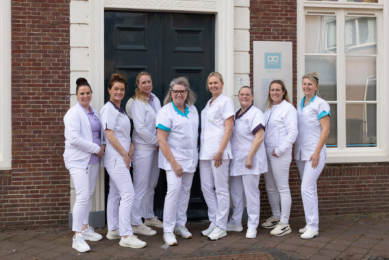 Team photo in front of Dental Clinics