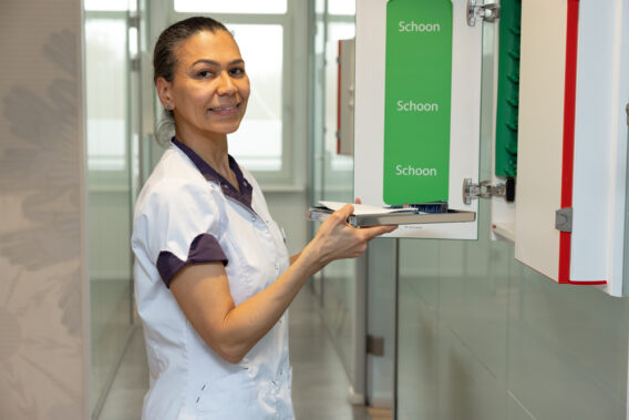 Assistent haalt dienblad uit schone kast Dental Clinics Haarlem Zijlweg
