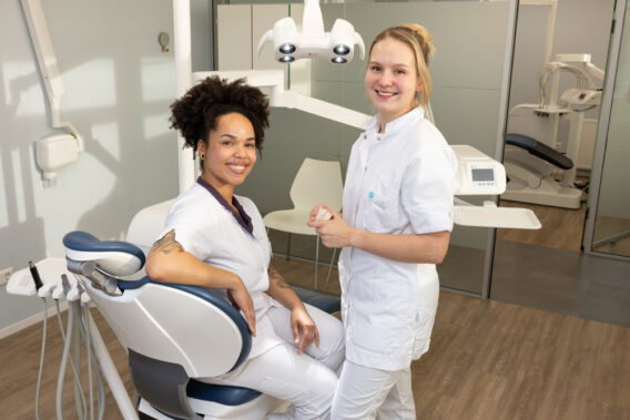 Twee behandelaren in behandelkamer, waarvan één op de stoel zit Dental Clinics Haarlem Zijlweg