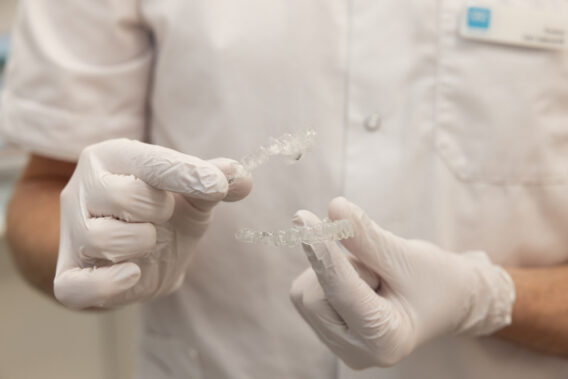 Handen van de tandarts die twee aligners vasthouden Dental Clinics Purmerend Weidevenne