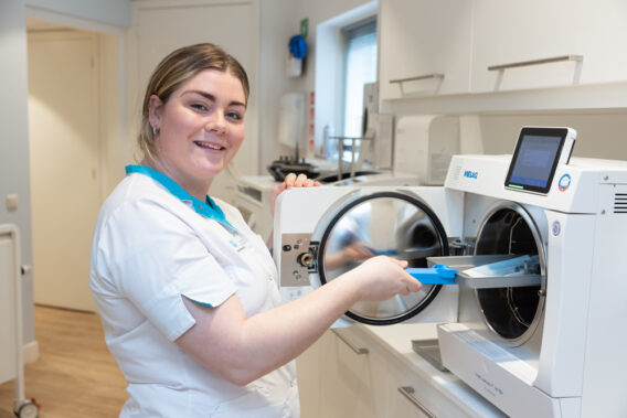 Omloopassistent haalt schoon dienblad uit autoclaaf Dental Clinics Purmerend Weidevenne