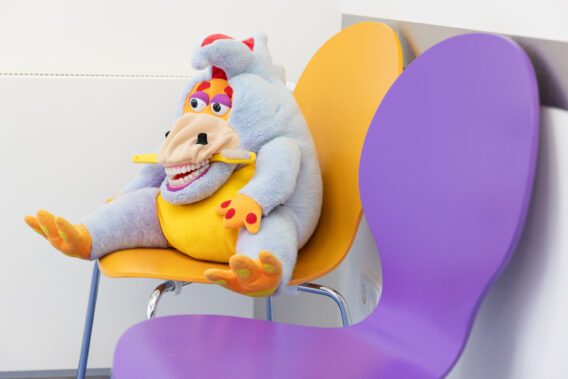 Poetsbeest met tandenborstel zit op stoel Dental Clinics Vught