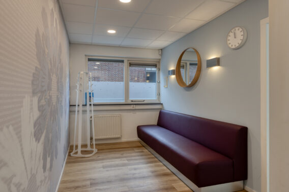 Interieur met bank en kapstok Dental Clinics Den Bosch
