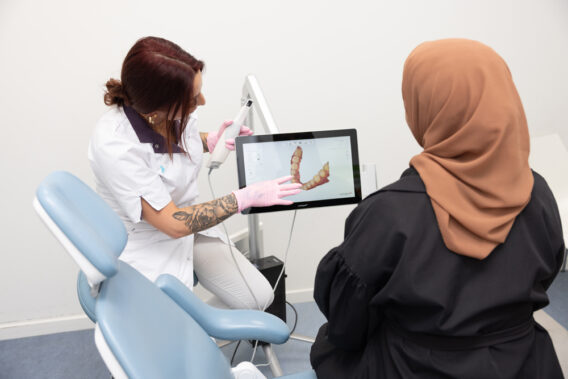 Mondhygiënist laat iets op het scherm zien aan de patiënt