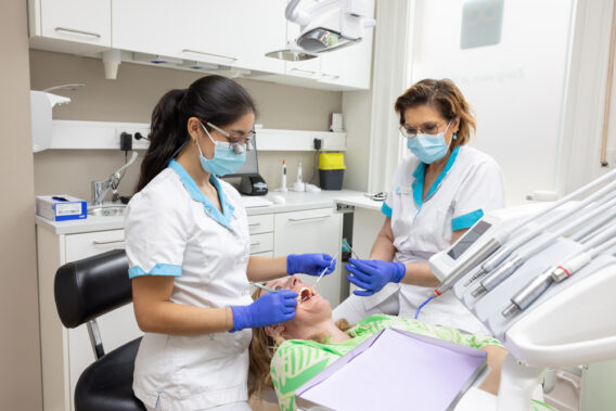 Tandarts en tandartsassistent behandelen patiënt bij Dental Clinics Steenbergen