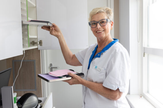 Omloopassistent pakt schoon tray uit de kast Dental Clinics Noordwijk