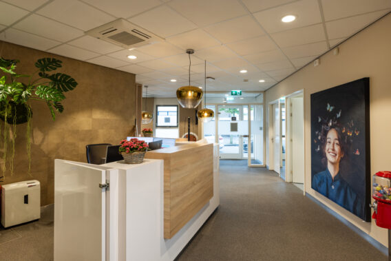 A view through the reception desk toward the windows at Dental Clinics