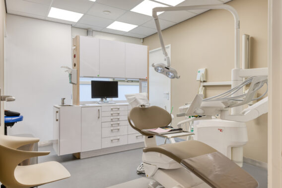 A treatment room with a chair at Dental Clinics