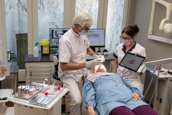 Tandarts behandelt patiënt in de kamer bij Dental Clinics Bloemendaal